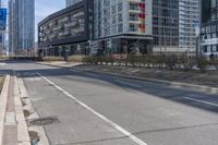 the empty street is lined with buildings in the background of a cityscape and a bicycle lane