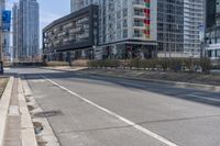 the empty street is lined with buildings in the background of a cityscape and a bicycle lane