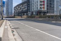 the empty street is lined with buildings in the background of a cityscape and a bicycle lane