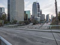 an empty city street with high rise buildings in the background and cars on the roadway