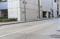 a empty city street with a man walking across it with a hat on his head