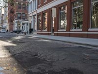 a very big empty city street with a red and white fire hydrant near the curb