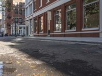 a very big empty city street with a red and white fire hydrant near the curb