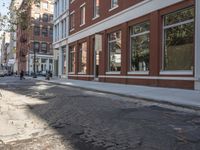 a very big empty city street with a red and white fire hydrant near the curb