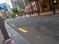 an empty city street lined with tall buildings and sidewalk lights on a sunny day a traffic light near a black paved street