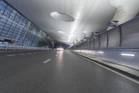 an empty street inside a modern building with skylights over it, and no people in the image