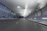 an empty street inside a modern building with skylights over it, and no people in the image