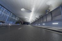 an empty street inside a modern building with skylights over it, and no people in the image