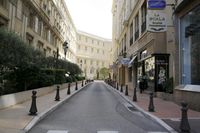 an empty city street in an area where it's busy and very narrow, but the buildings are very tall
