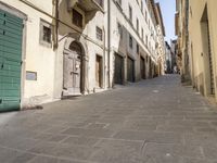 an empty city street with two motorcycles parked on either side of the road, and some people