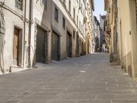 an empty city street with two motorcycles parked on either side of the road, and some people