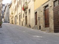 an empty city street with two motorcycles parked on either side of the road, and some people