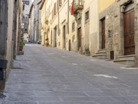 an empty city street with two motorcycles parked on either side of the road, and some people