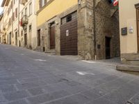 an empty city street with two motorcycles parked on either side of the road, and some people