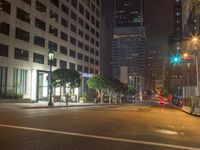this empty street is at night with lots of buildings in the background while no one can tell