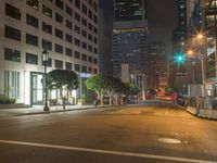 this empty street is at night with lots of buildings in the background while no one can tell