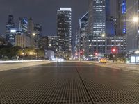 an empty city street with city lights and grates on the ground and buildings in the background