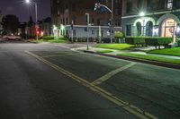 an empty city street at night during the day with cars stopped to stop and look over the intersection