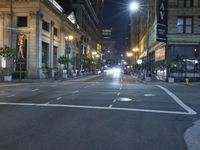 an empty city street at night with no traffic cones on it, with lights on