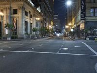 an empty city street at night with no traffic cones on it, with lights on