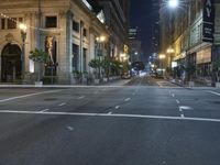 an empty city street at night with no traffic cones on it, with lights on