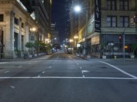 an empty city street at night with no traffic cones on it, with lights on