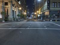 an empty city street at night with no traffic cones on it, with lights on