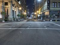 an empty city street at night with no traffic cones on it, with lights on