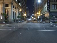 an empty city street at night with no traffic cones on it, with lights on