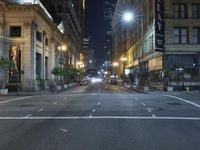 an empty city street at night with no traffic cones on it, with lights on