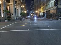 an empty city street at night with no traffic cones on it, with lights on