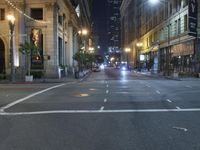 an empty city street at night with no traffic cones on it, with lights on