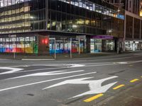 the street that is empty in the city at night time with an arrow sign on it