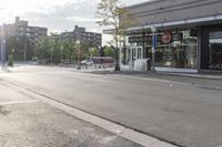 an empty city street with some stores on the side of it and a parking lot next to it