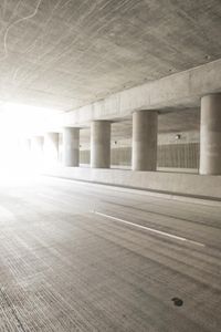 an empty city street is shown at an overpass, with two long sections of concrete and windows on either side