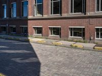 the corner of an empty city street is made from red brick, with yellow border