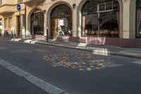 an empty city street is painted with dots in the road as well as buildings and people