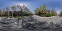 a fish eye view of an empty city street with some tall houses in the background