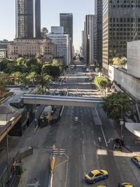 an empty city street, with taxis and cars on it and people on either side of the road