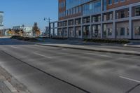 an empty city street and large buildings in the background as seen from the side of the road