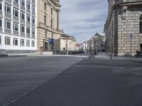 a city street is empty and filled with cars, scooters and pedestrians on the side