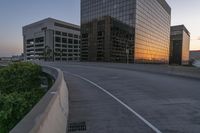 the street is empty, and there are no cars going through this area while the sun is setting