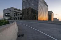 the street is empty, and there are no cars going through this area while the sun is setting