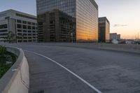 the street is empty, and there are no cars going through this area while the sun is setting