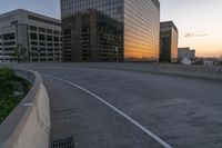 the street is empty, and there are no cars going through this area while the sun is setting