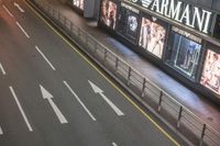 the streets and signs are both empty at night with no people on it and a person crossing