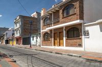 an empty cobblestone street with brick buildings and wooden doors that are open on each side