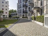 an empty cobblestone street between two multi -story buildings in a city