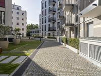 an empty cobblestone street between two multi -story buildings in a city