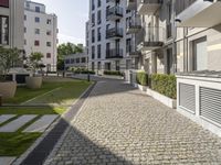 an empty cobblestone street between two multi -story buildings in a city